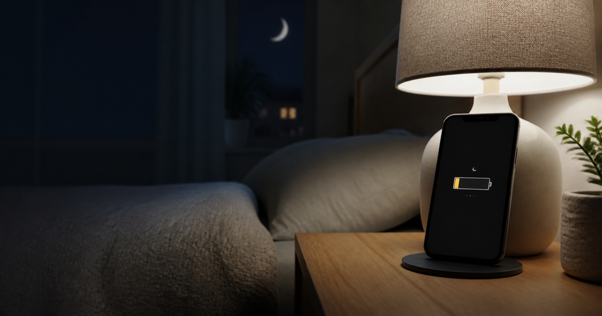 Phone with a low battery beside a bedside lamp